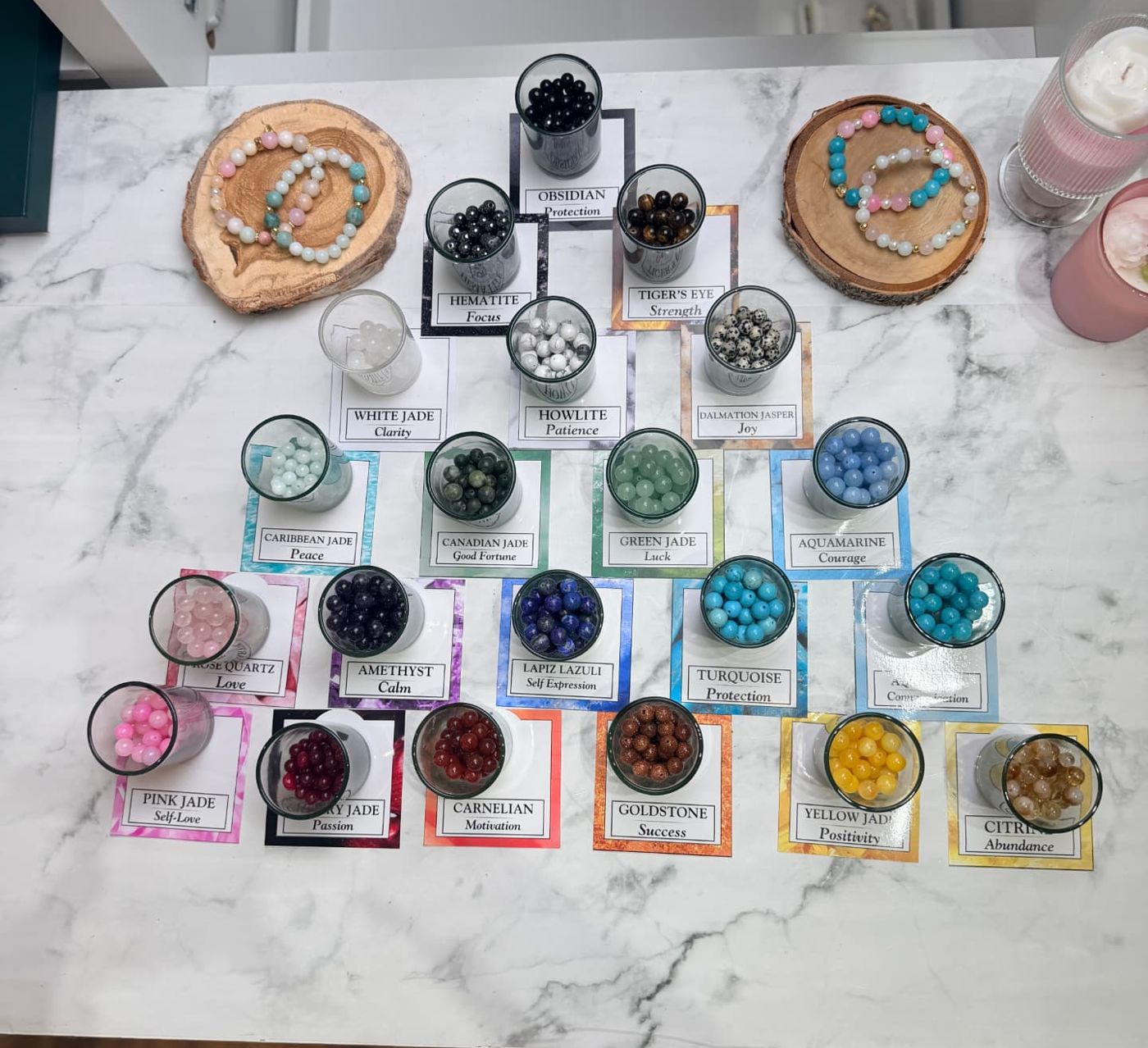ROMALI Bead Bar table with labelled glasses of gemstone beads such as obsidian, amethyst, turquoise and pink jade, and sample beaded bracelets.